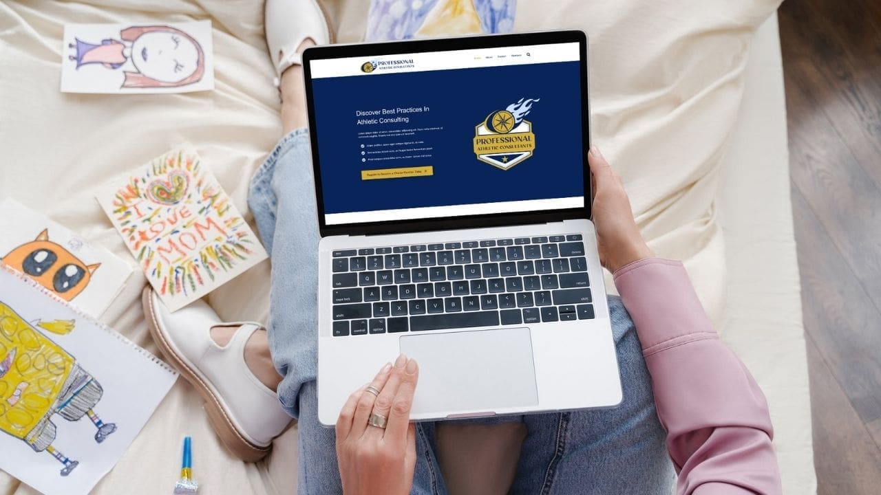 overhead view of someone sitting on a bed with a laptop in their lap. The laptop shows the PAC website homepage